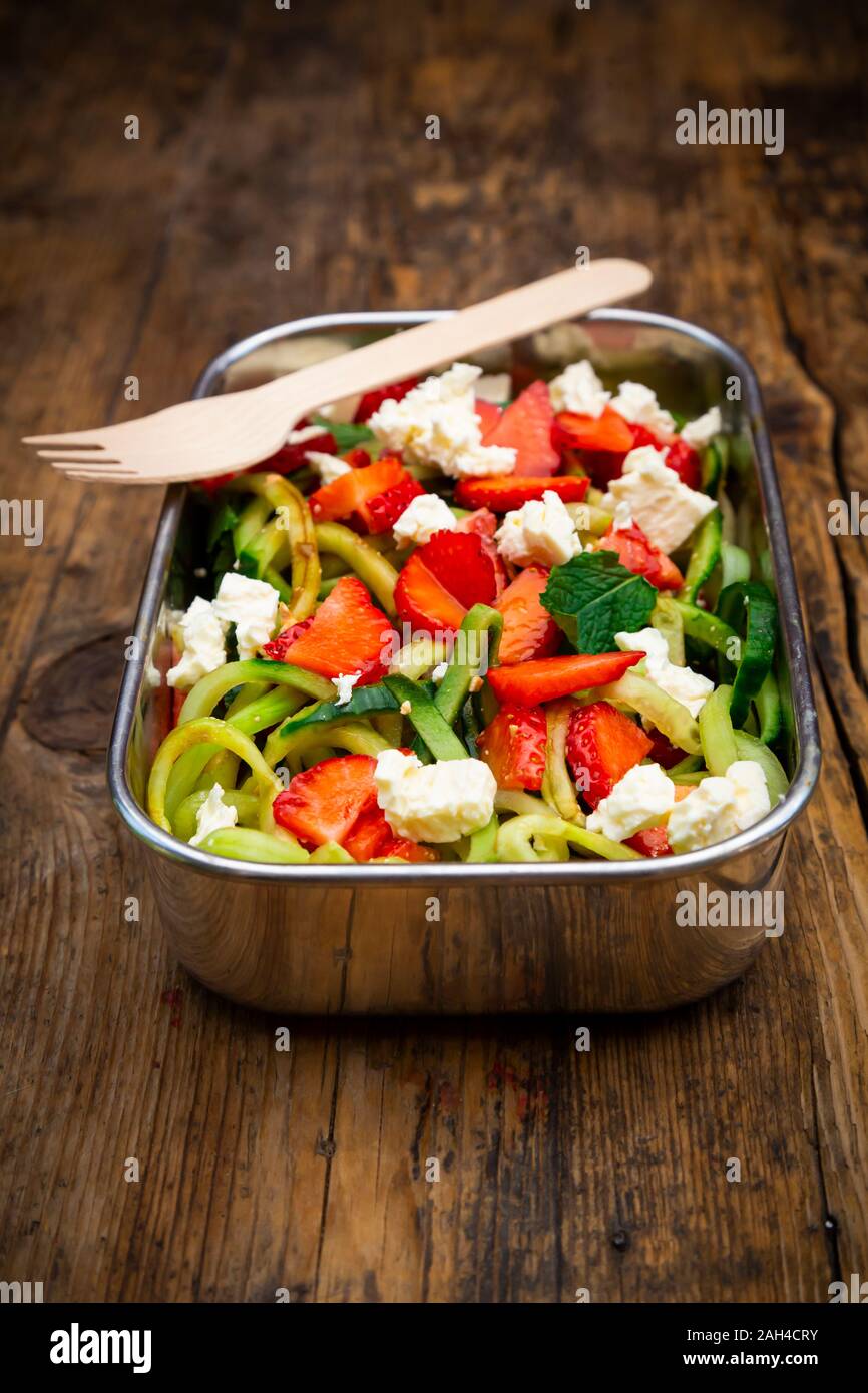 Metall lunchbox mit Gurke und Erdbeere, Salat mit Feta Käse, Minze und Balsamico Essig gemischt Stockfoto
