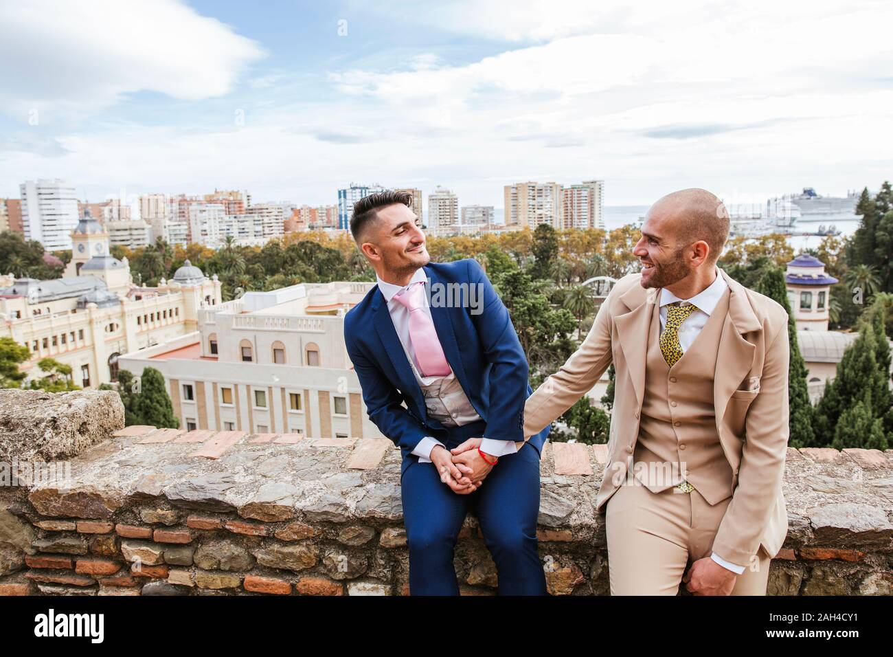 Elegante homosexuelles Paar halten sich an den Händen an einem Aussichtspunkt über der Stadt, Malaga, Spanien Stockfoto