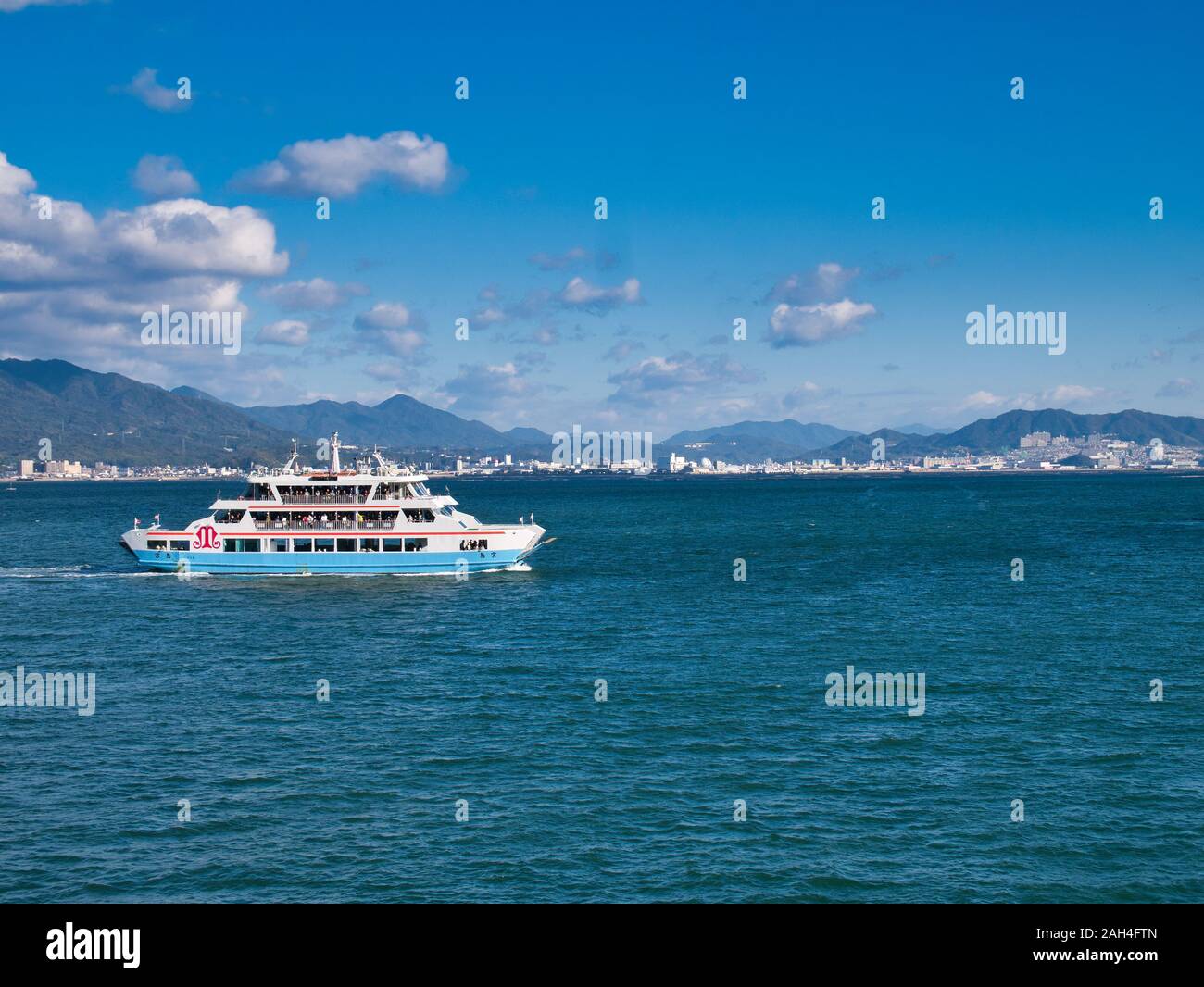 Ein Roll-on/Roll-off-Fähre mit Passagieren fährt zwischen Miyajimaguchi Station und der Insel Miyajima in der Bucht von Hiroshima geladen. Stockfoto