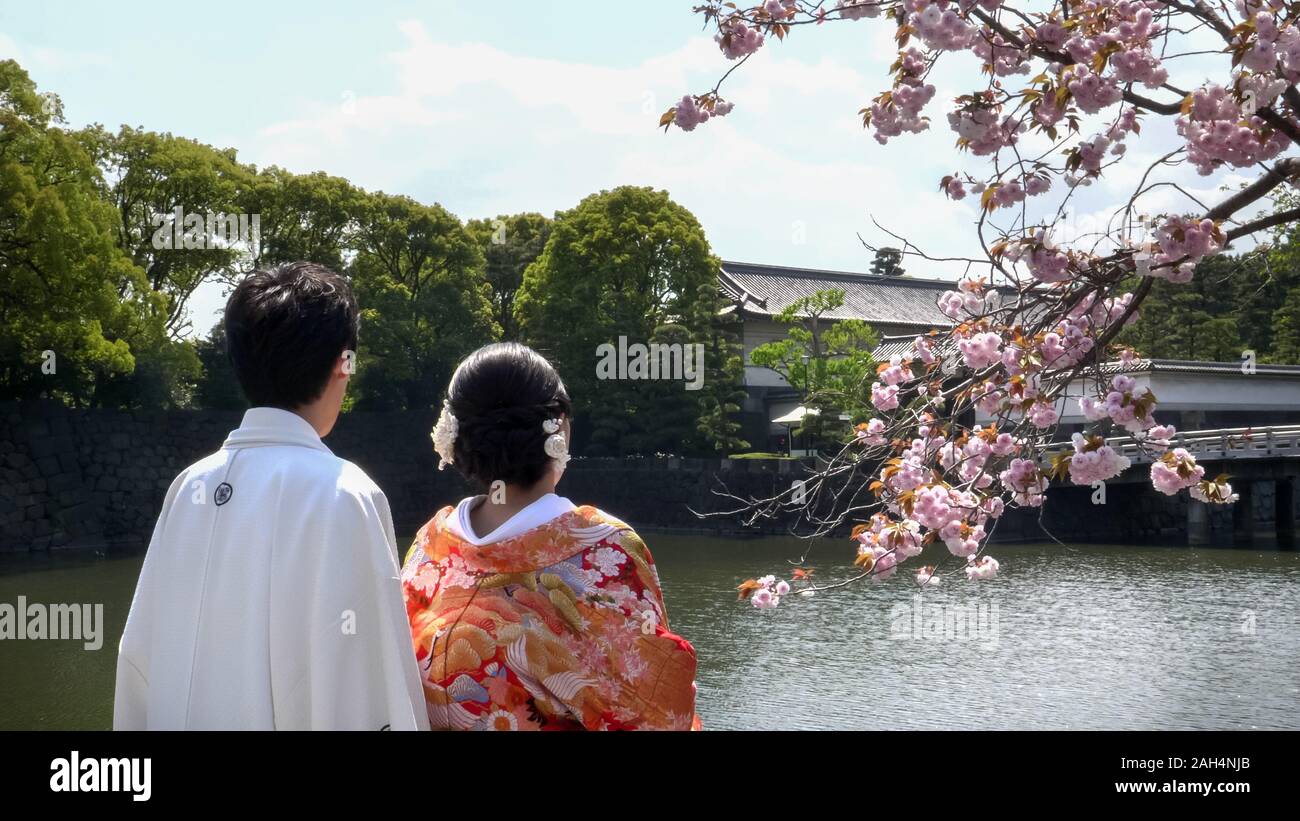 Tokio, Japan - April, 10, 2018: Japanische Braut und Bräutigam bewundern Kirschblüten im Imperial Palace in Tokio Stockfoto