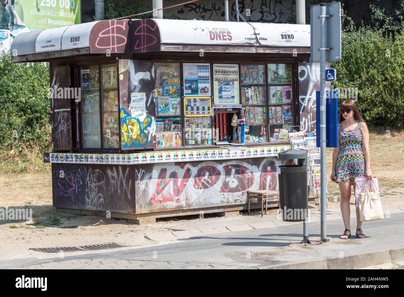 Frau lesen Bus Fahrplan an der Haltestelle außerhalb Kiosk, Brno, Tschechische Republik Stockfoto