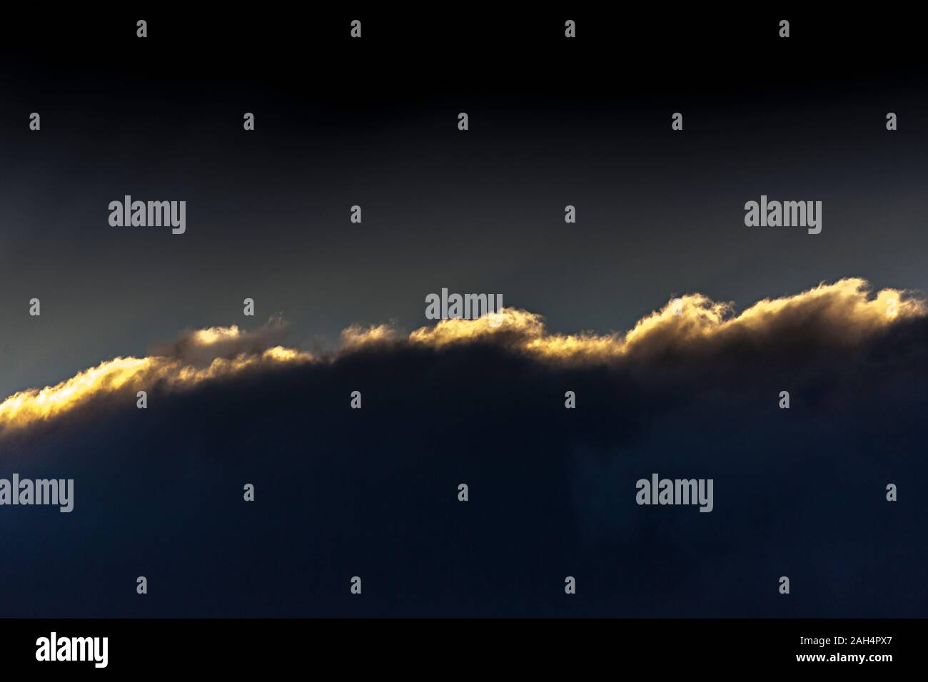 Bank von Cloud mit Sonnenuntergang Highlights gegen den dunklen Himmel Stockfoto
