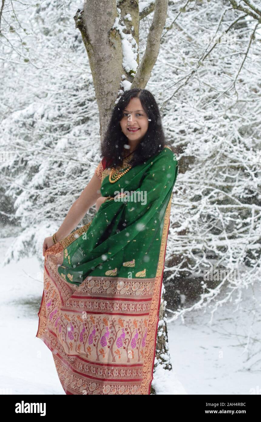 Traditionell gekleidete zuversichtlich indische Frau genießen Schneefall Stockfoto