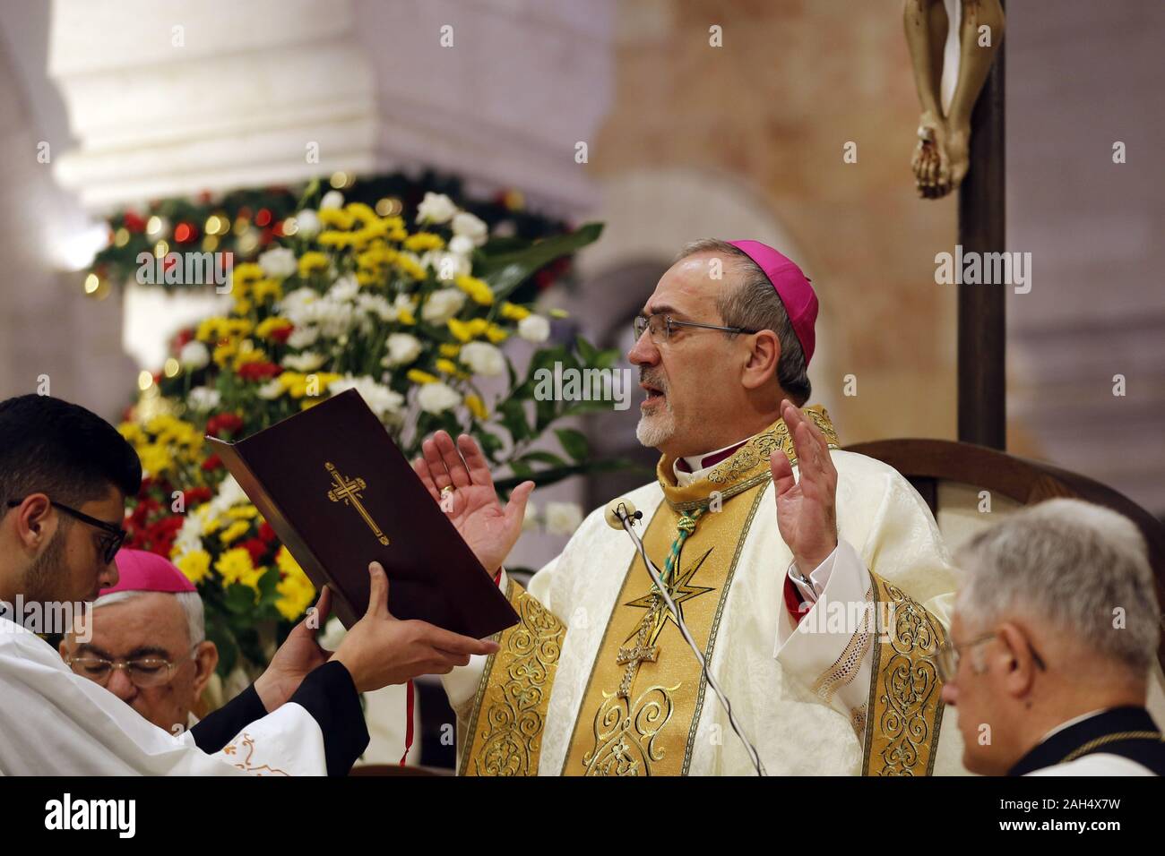 Bethlehem, West Bank. 24 Dez, 2019. Der lateinische Patriarch von Jerusalem, Pierbattista Pizzaballa führt einen weihnachtlichen Mitternachtsmesse in der Geburtskirche in Bethlehem im israelisch besetzten Westjordanland am Mittwoch, den 25. Dezember 2019. Pool Foto von Mussa Qawasma/UPI Quelle: UPI/Alamy leben Nachrichten Stockfoto