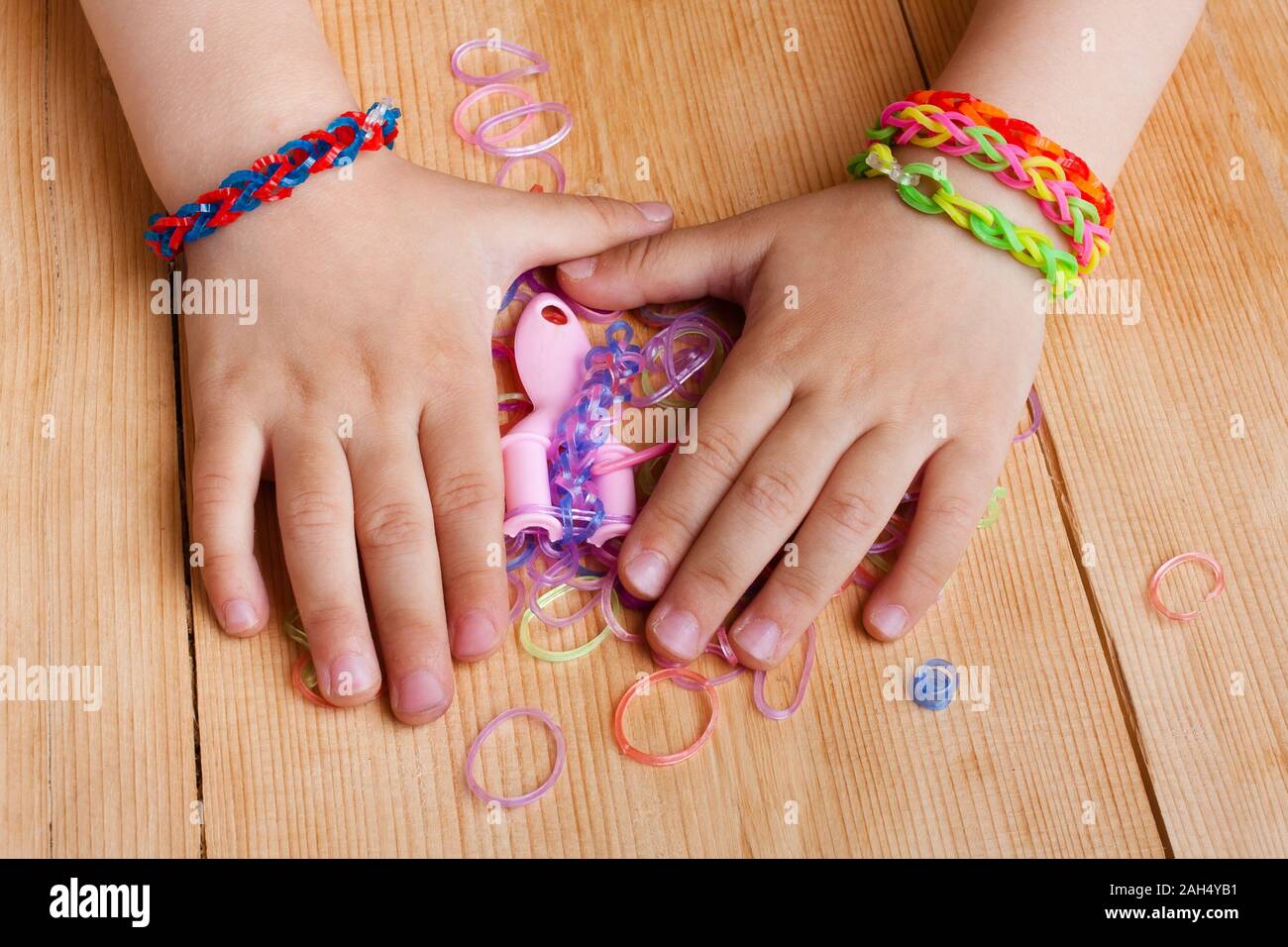 Kind Hände mit Gummibänder auf dem hölzernen Tisch Stockfoto