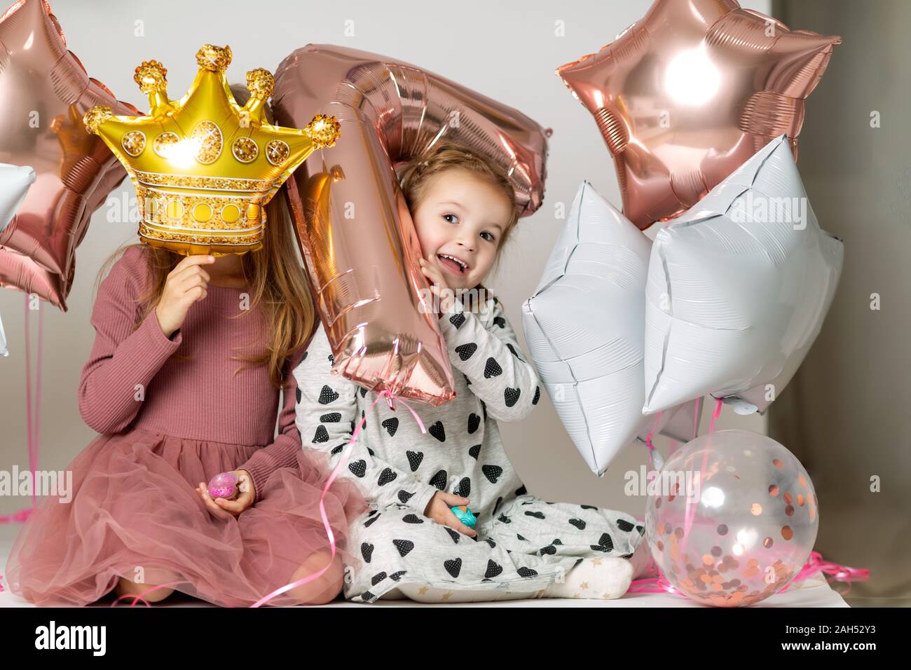 Mädchen spielen mit Ballons auf weißem Hintergrund Stockfoto