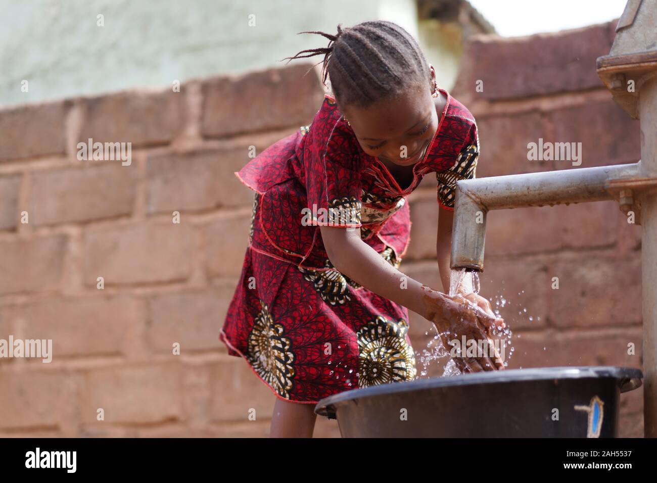 Young African Girl Reinigen Sie Ihre Hände Mit Frischem Wasser Am Bohrloch Stockfoto