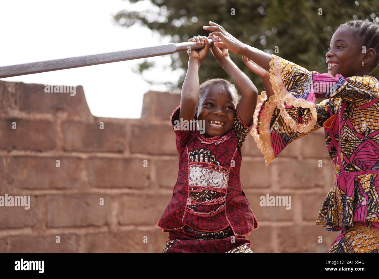 Zwei Kleine afrikanische Mädchen, Die An der Wasserpumpe Spielen Stockfoto