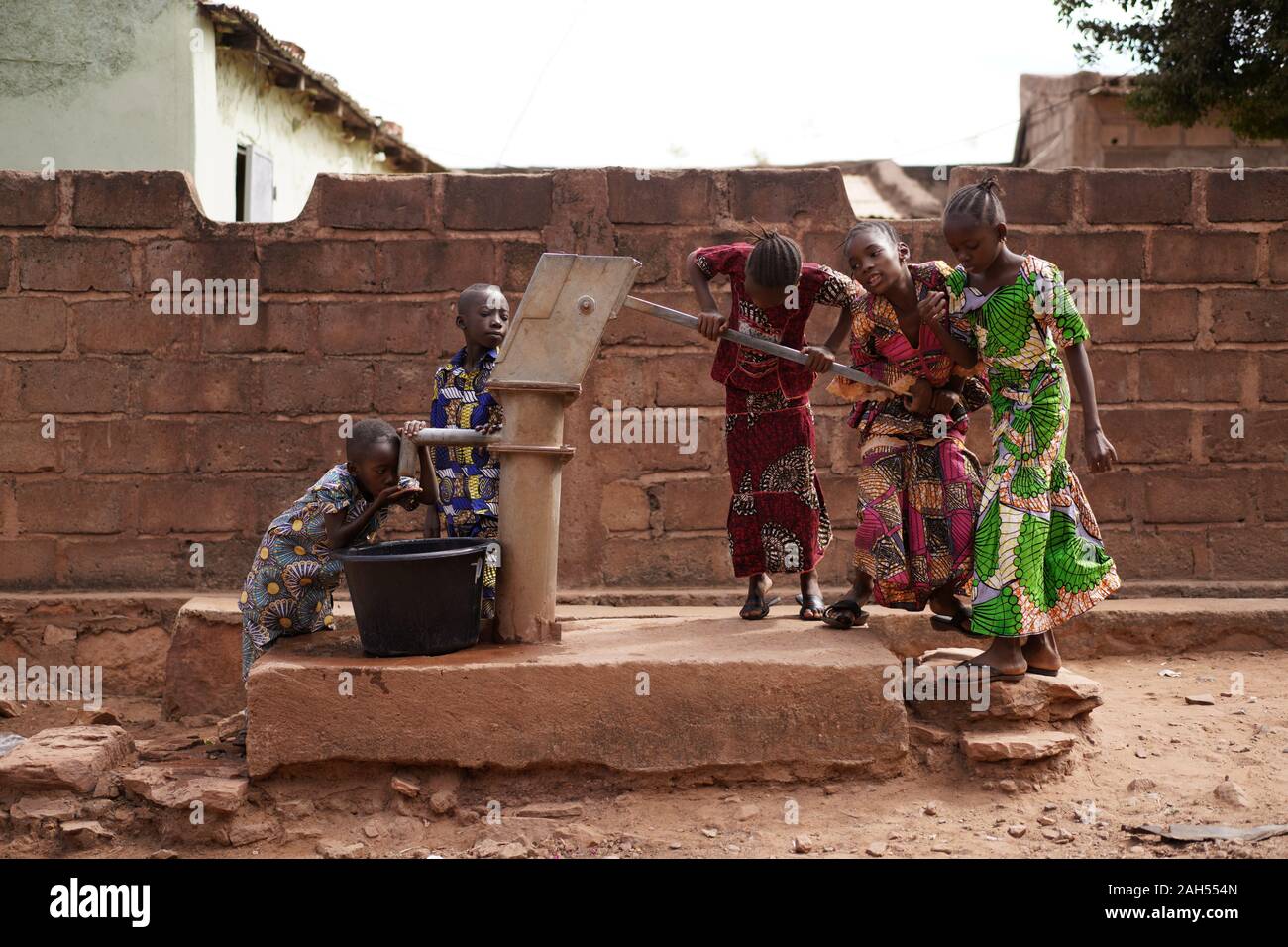 Afrikanische Kinder Holen Trinkwasser An Ihrer Modernen Wasserpumpe Im Dorf Stockfoto