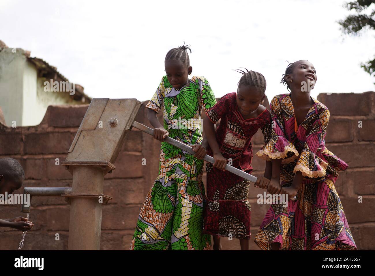 Gruppe Kleiner westafrikanischer Mädchen, Die Wasser Zusammenpumpen Stockfoto