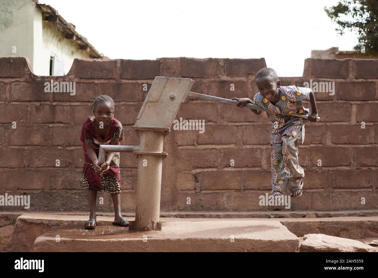Zwei Kleine afrikanische Kinder Scherzten Mit EINER Wasserpumpe Stockfoto