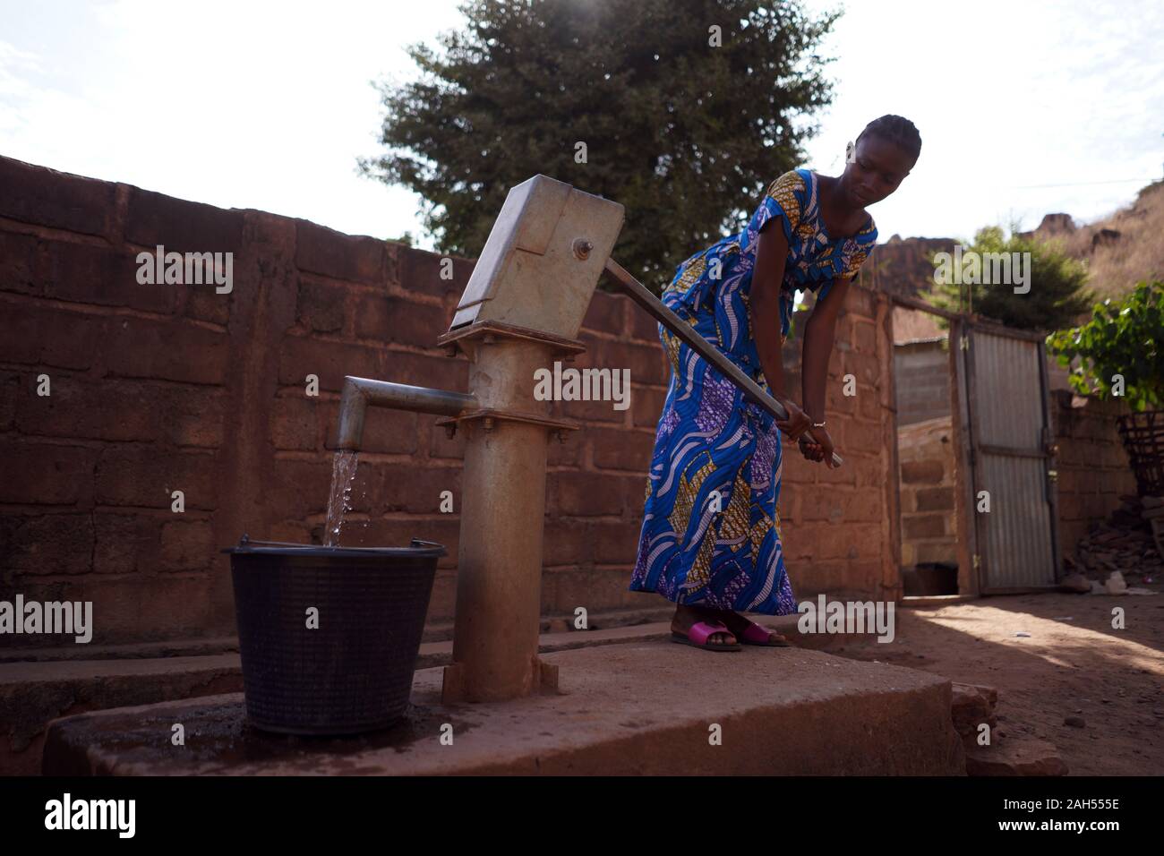 Junge Afrikanerin Sammelt Wasser An Der Dorfpumpe Stockfoto