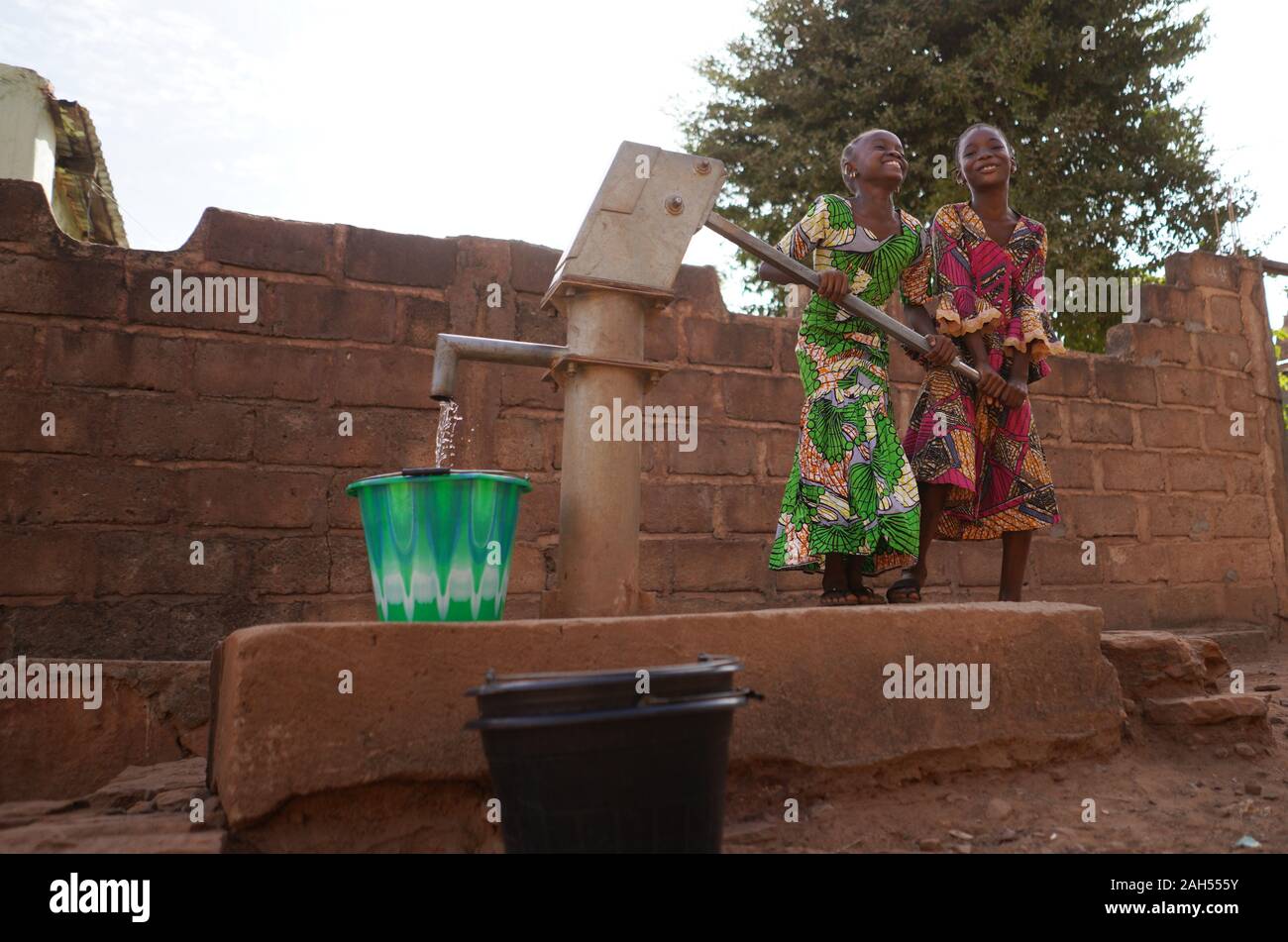 Zwei Afrikanische Mädchen Füllen Eimer Mit Sauberem Wasser Stockfoto