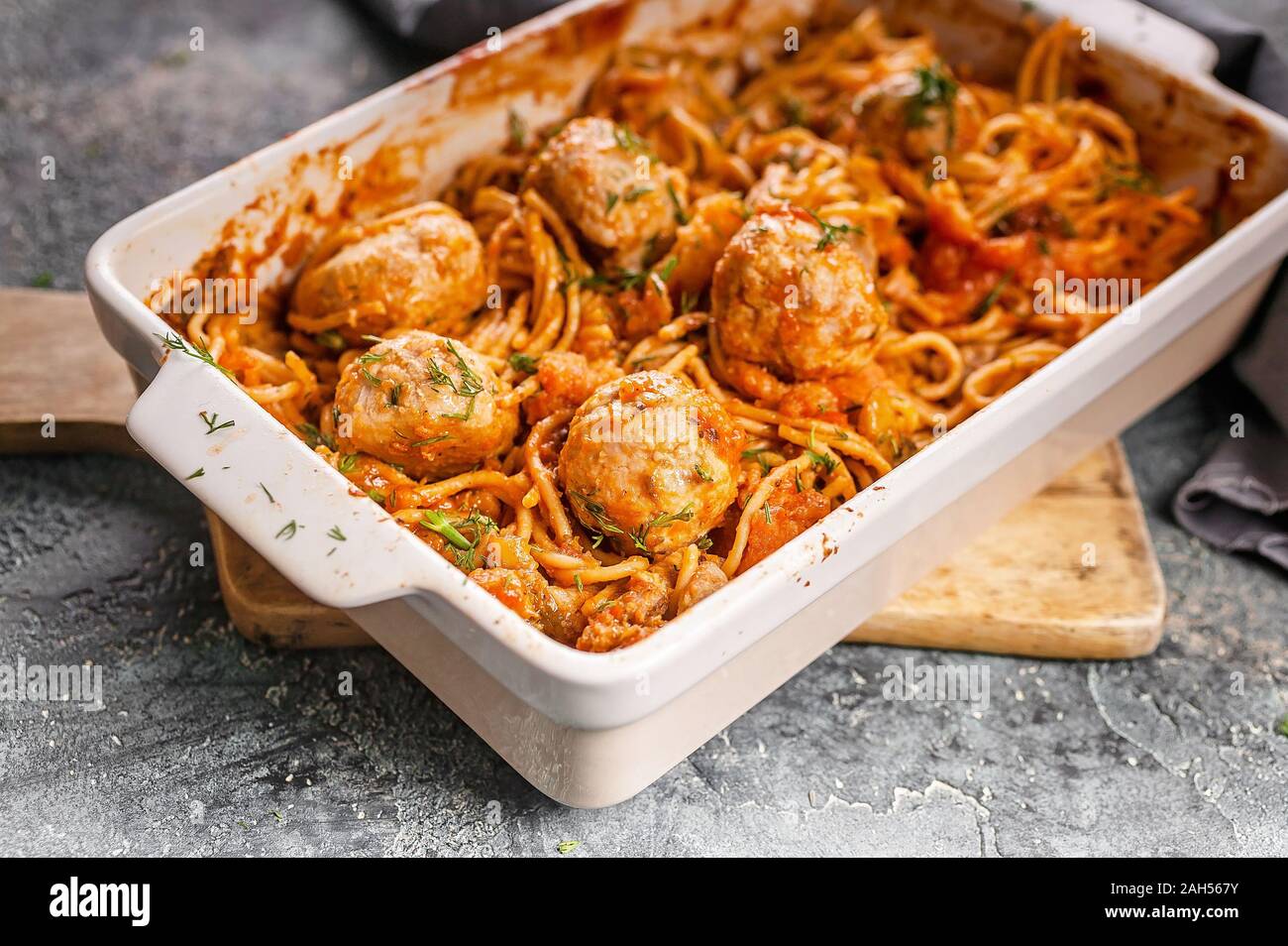 Close-up Spaghetti mit Fleischbällchen mit Tomaten und Kräutern in einer Auflaufform. Traditionellen italienischen Pasta. Mediterrane Küche Stockfoto