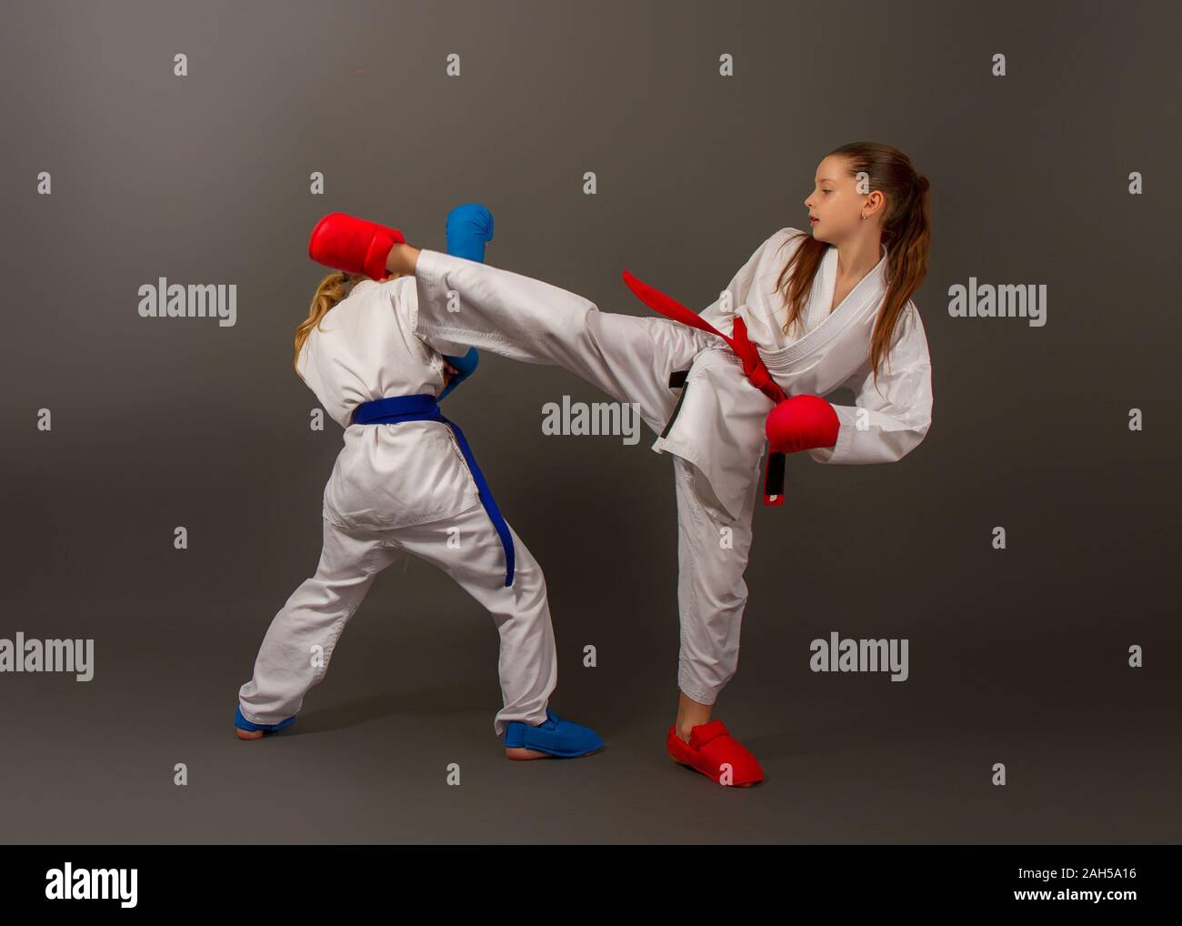 Sport Karate kämpfen zwei kleine Mädchen in weißen Kimono Rot eine Sekunde in Blau schützende Kits Stockfoto