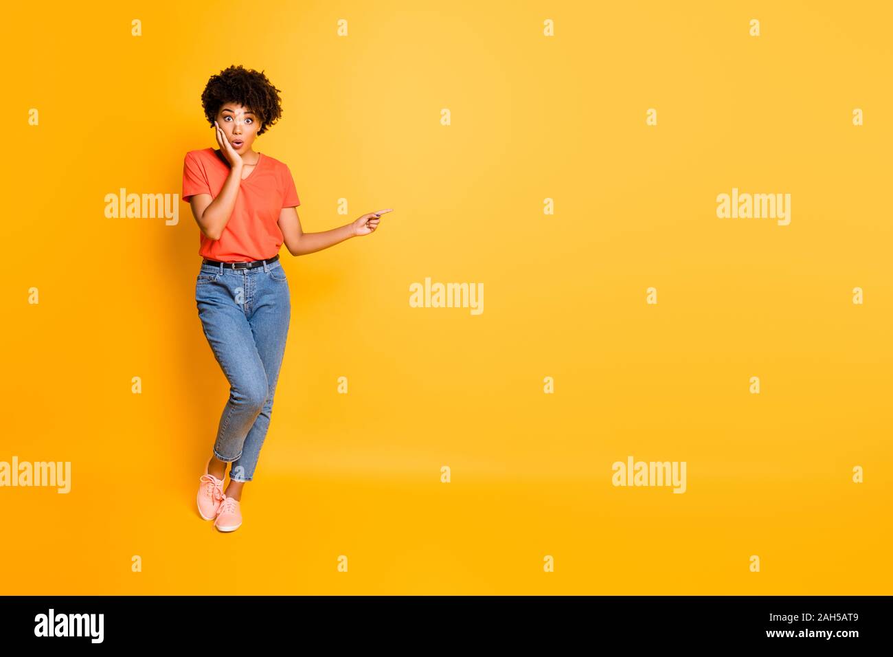 Volle Länge Körpergröße copyspace Foto von schockiert stilvoll trendy recht süsse, nette schöne schwarze Frau in Jeans Denim t-shirt zeigt auf emptines Stockfoto