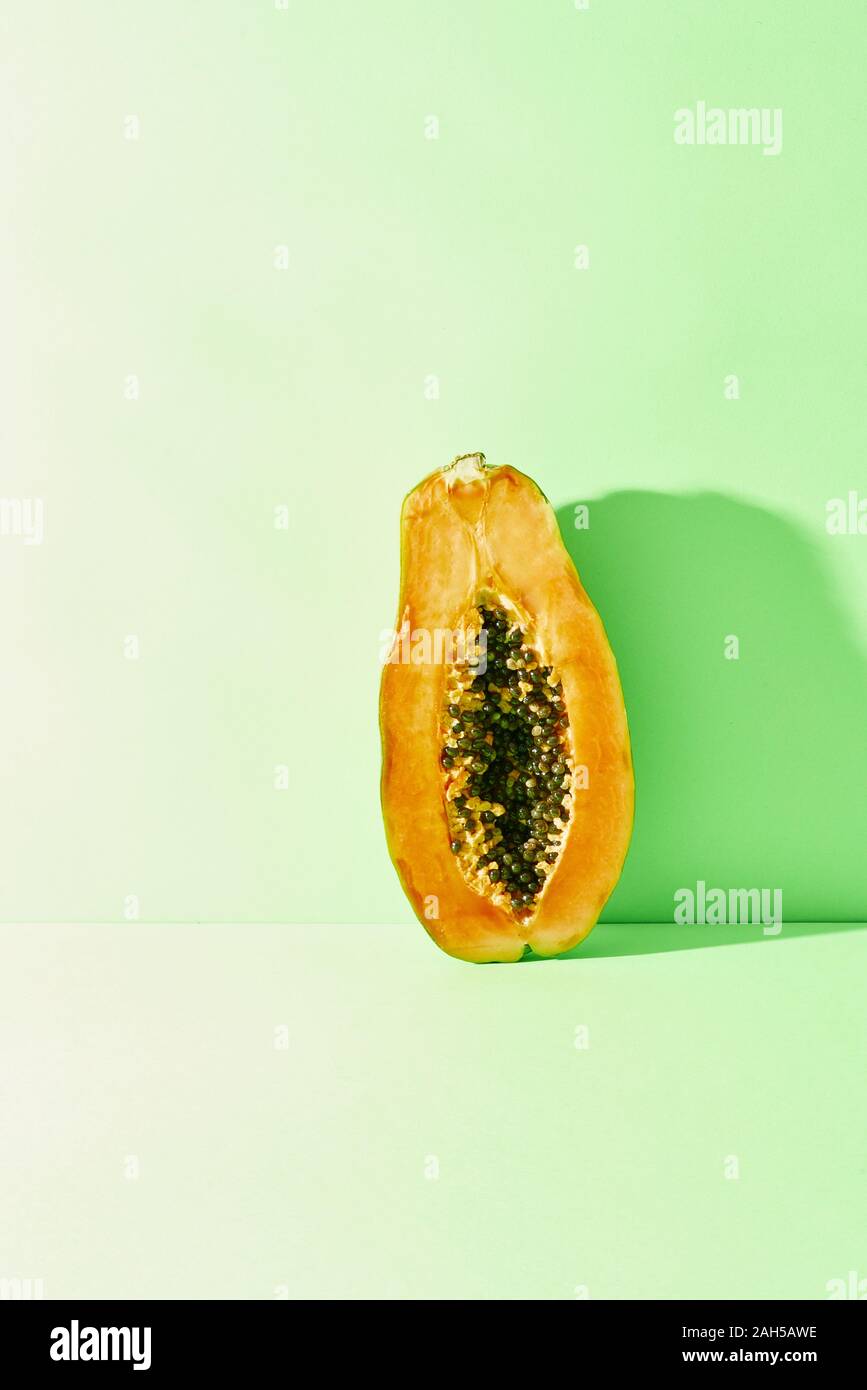 Die Hälfte der Reif und saftig Papaya steht auf einem blauen Hintergrund Stockfoto