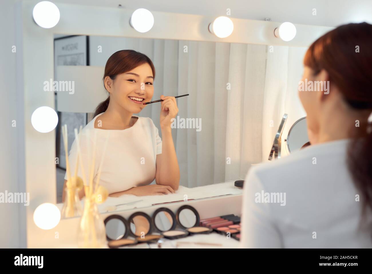 Schöne Frau mit Schönheit Gesicht Anwendung Lippenbalsam, Lipcare Stick auf. Lippen Hautpflege Kosmetik Konzept. Stockfoto