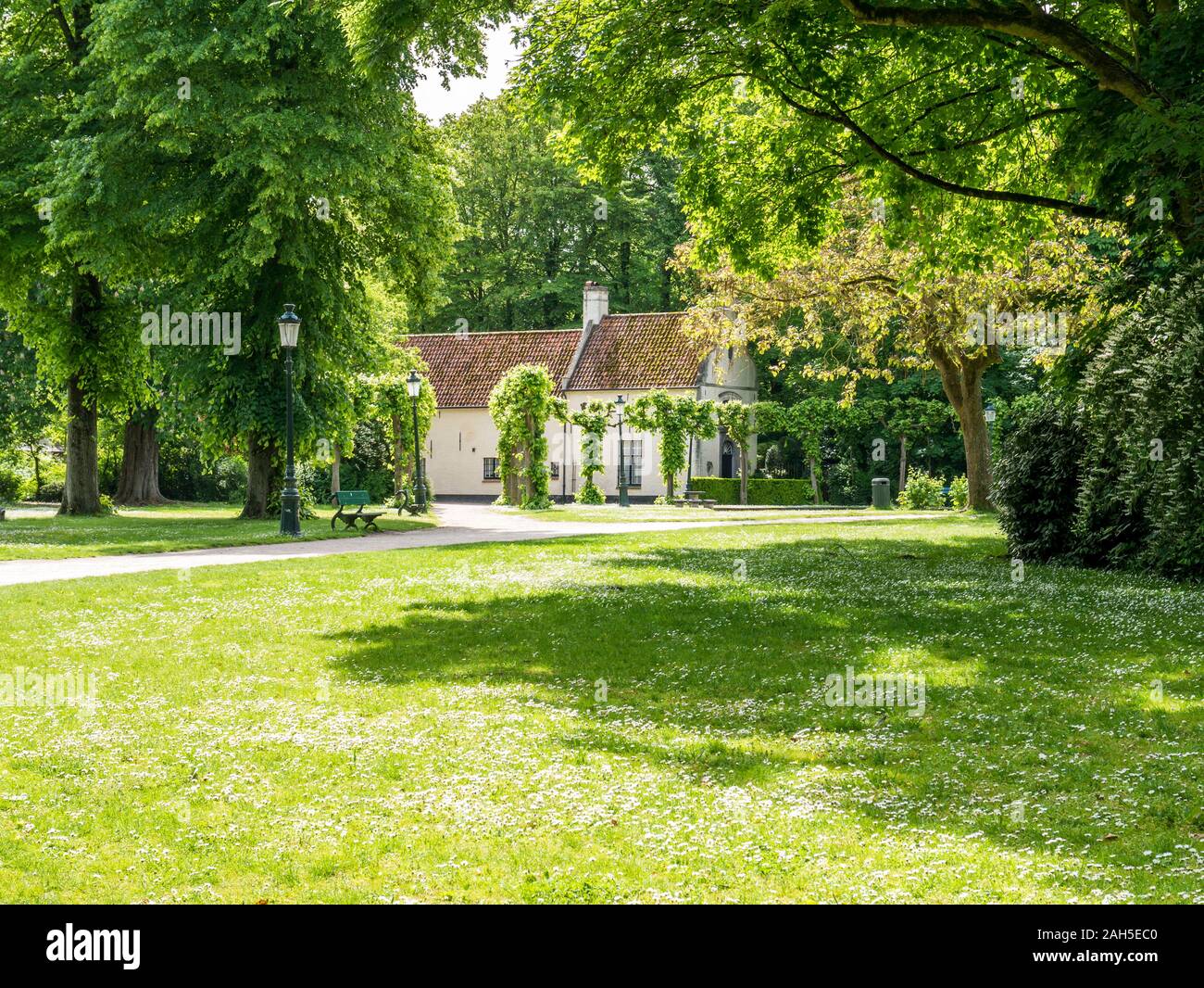Grüne Wiese, Haus und Bäume in der Minnewaterpark in Brügge, Westflandern, Belgien Stockfoto