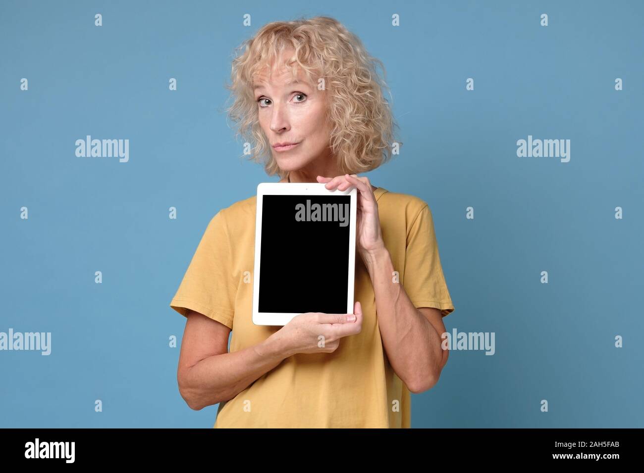 Ältere Frau zeigen Anzeige der Tablette mit schwarzer Bildschirm und lächelnd Stockfoto