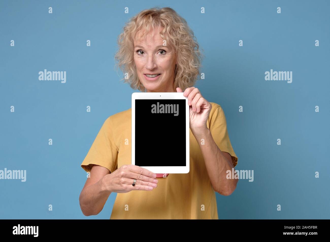 Ältere Frau zeigen Anzeige der Tablette mit schwarzer Bildschirm und lächelnd Stockfoto