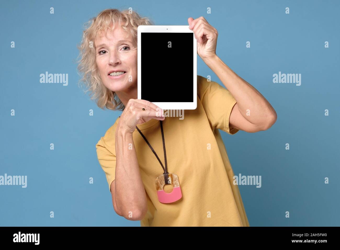 Ältere Frau zeigen Anzeige der Tablette mit schwarzer Bildschirm und lächelnd Stockfoto