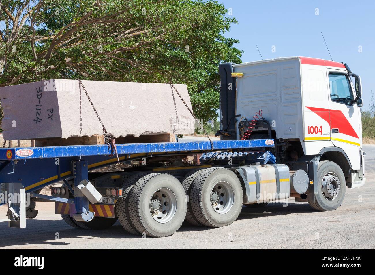 Großer Stein auf einer halb Lkw transportiert werden und Tieflader auf der Straße Stockfoto