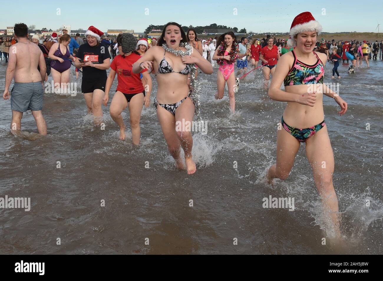 Schwimmer nehmen Sie teil am Weihnachtstag schwimmen in Porthcawl, Wales. Stockfoto