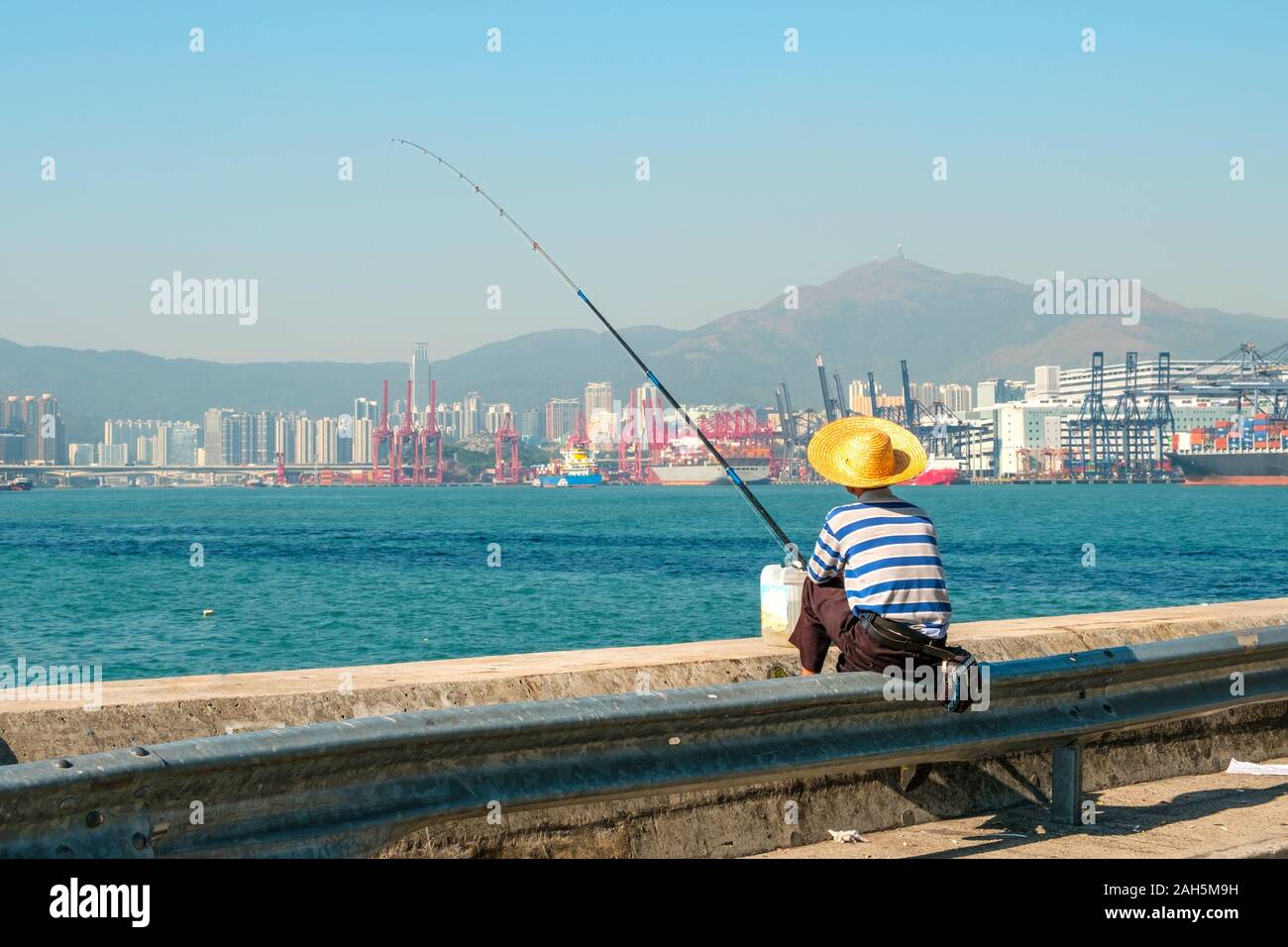 Fisher Mann mit Angelrute von hinten in der Nähe der Hafen in HongKong Stockfoto