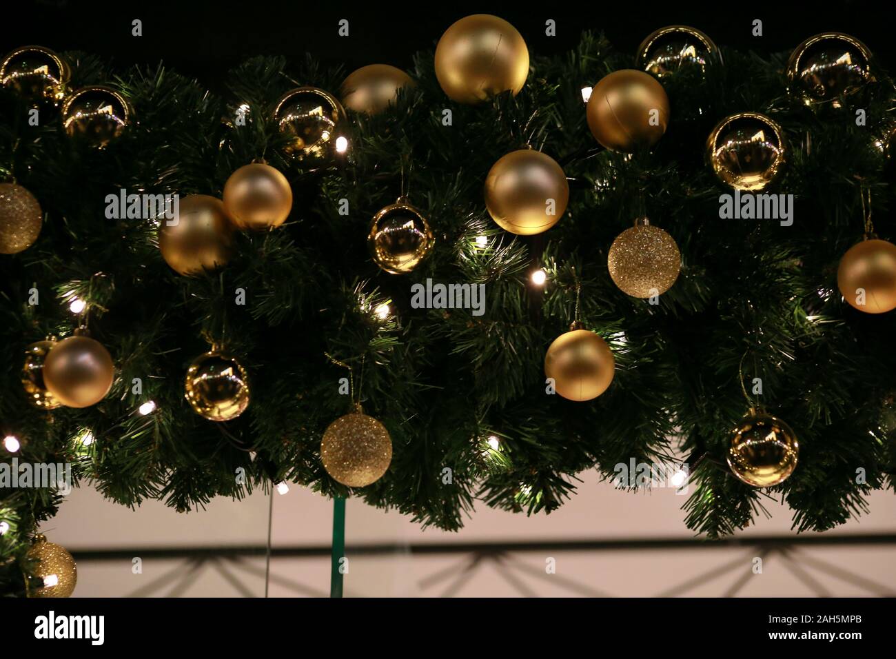 Traditionell dekorierte Christbaumkugeln auf Kranz aus Tannenzweigen und grün leuchtende