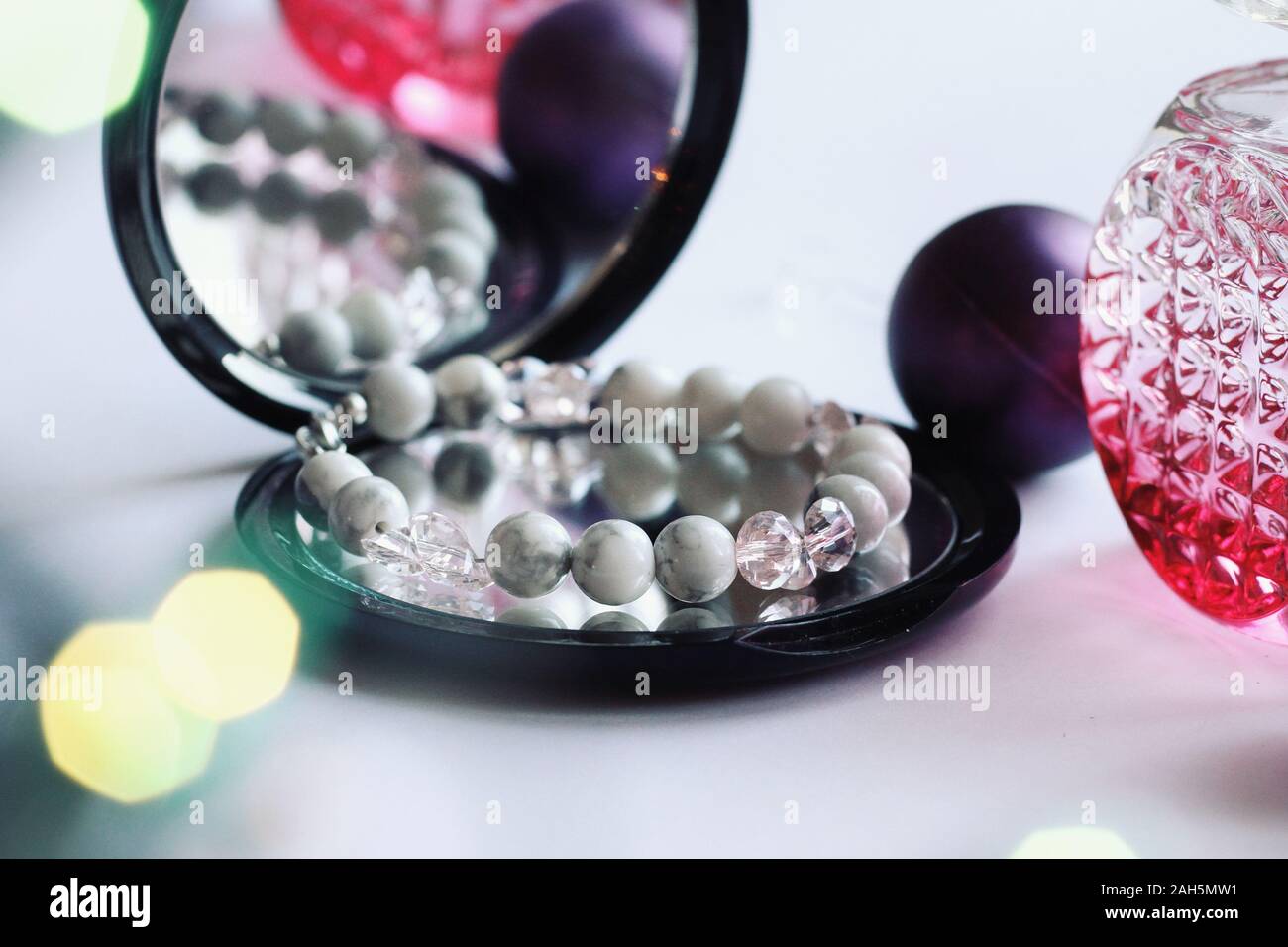 Schmuck Komposition mit Überlegungen im Spiegel. Armband mit Natursteinen für Geschenk, Weihnachten, Neujahr oder Geburtstag. Schönheit, Stil, Mode Konzept Stockfoto