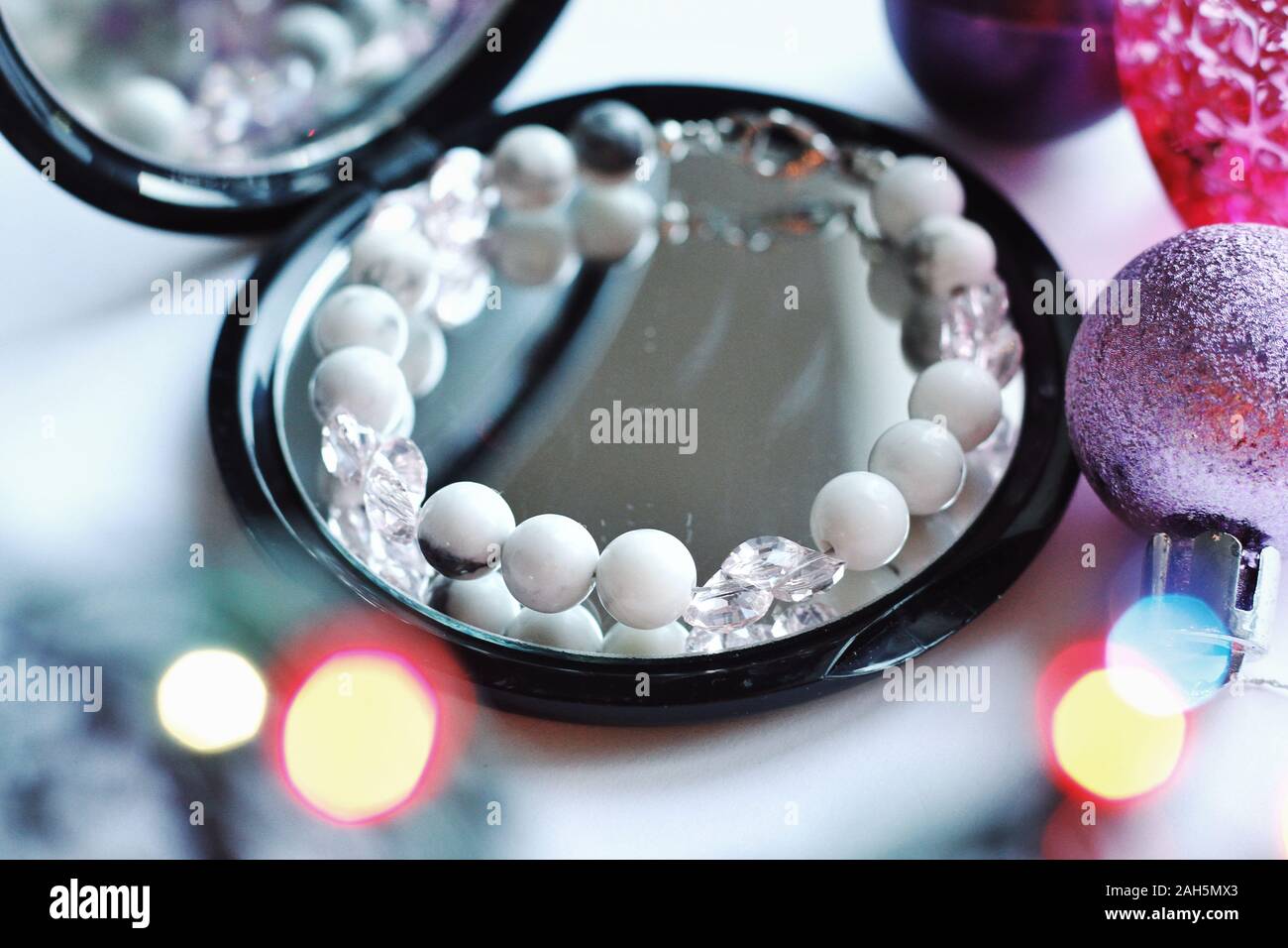 Schmuck Komposition mit Reflexionen in Spiegel mit Bokeh. Armband mit Natursteinen für Geschenk, Hochzeit oder Geburtstag. Schönheit, Stil, Mode Konzept Stockfoto