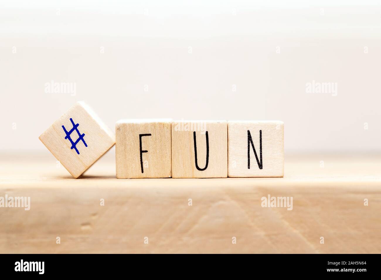 Holzwürfel mit hashtag und das Wort Spaß in verschiedenen Farben, social media Konzept Hintergrund Stockfoto