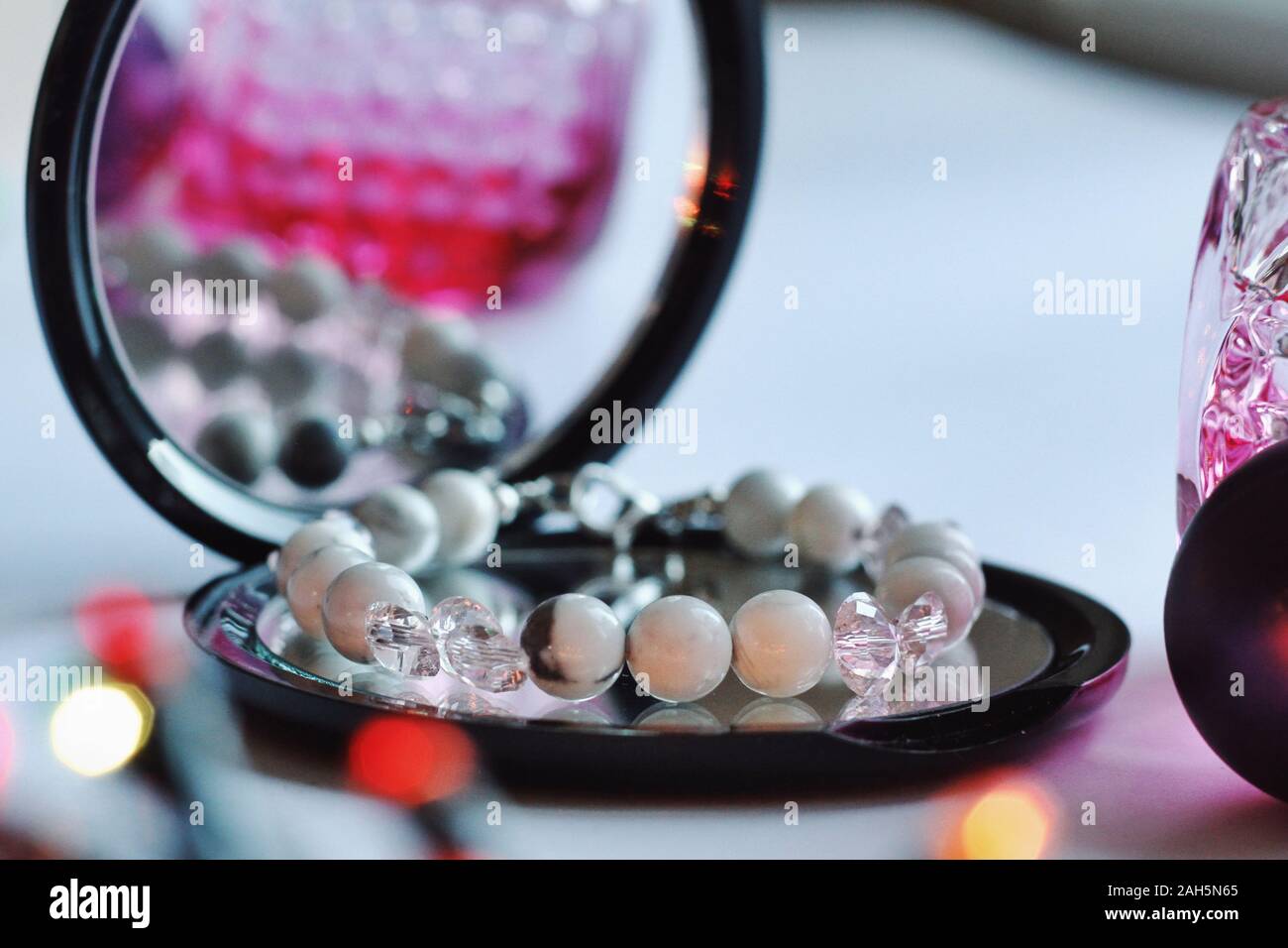 Schmuck Komposition mit Überlegungen im Spiegel. Armband mit Natursteinen für Geschenk, Weihnachten, Neujahr oder Geburtstag. Schönheit, Stil, Mode Konzept Stockfoto