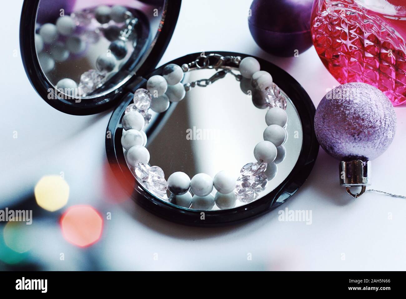 Schmuck Komposition mit Überlegungen im Spiegel. Armband mit Natursteinen für Geschenk, Weihnachten, Neujahr oder Geburtstag. Schönheit, Stil, Mode Konzept Stockfoto