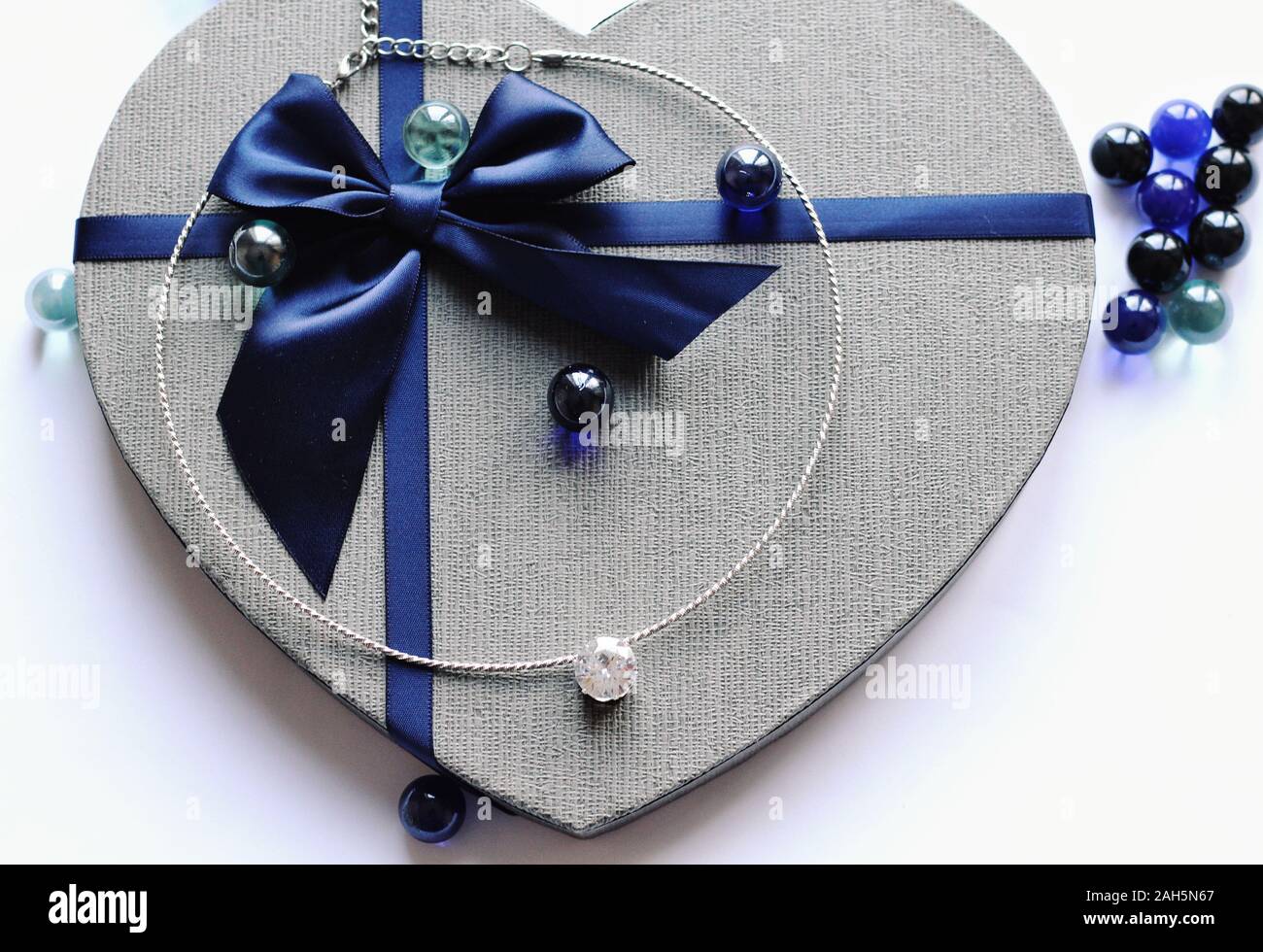 Ansicht von oben. Kalte Farben. Schmuck Zusammensetzung auf die inneren Hintergrund und Geschenkset in blauer Farbe. Chainlet mit Tender Edelstein für Geschenk, Heiraten, Neue Ja Stockfoto