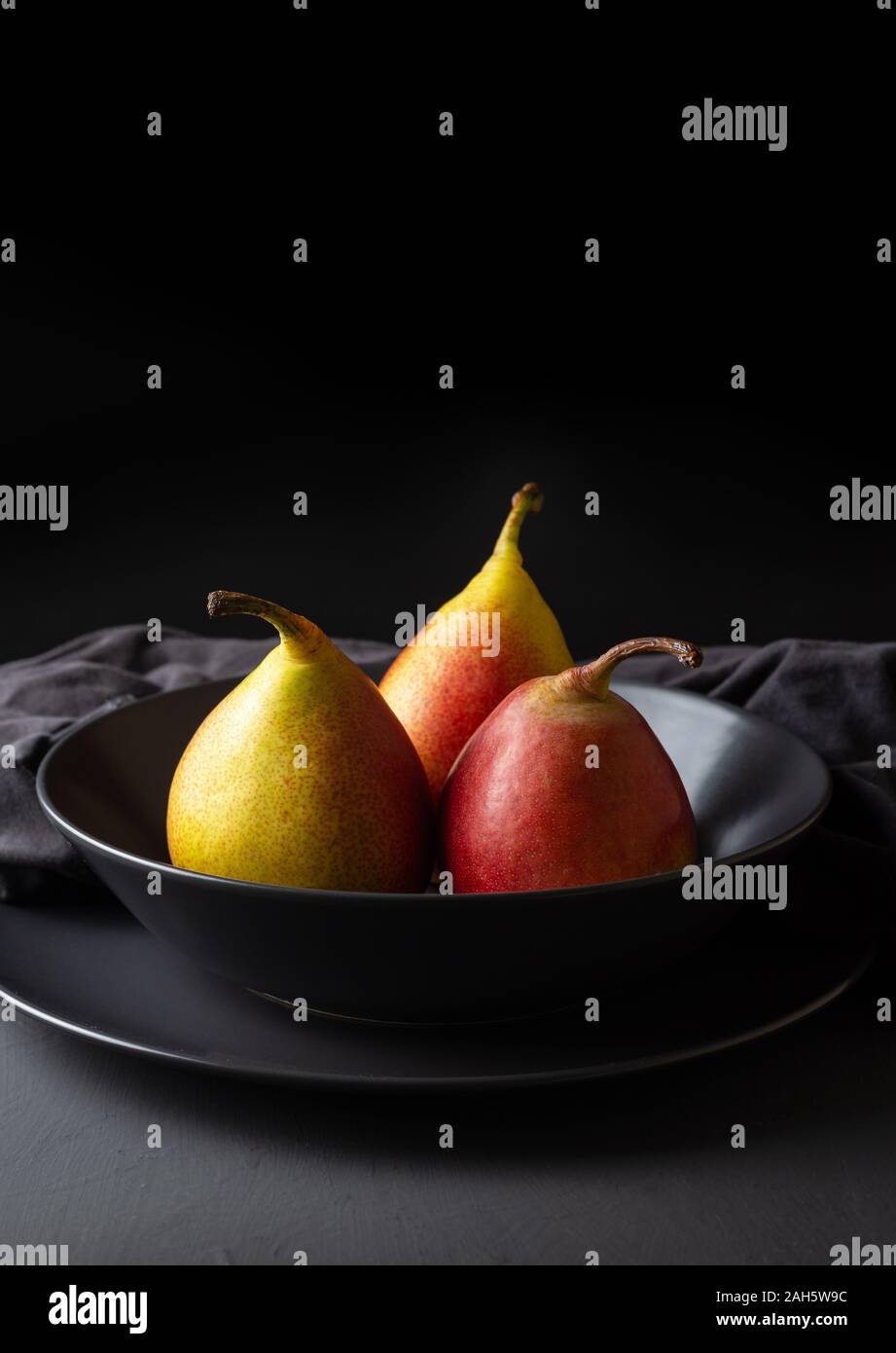 Drei frische saisonale Birnen auf dunklem Hintergrund, kopieren Raum Stockfoto