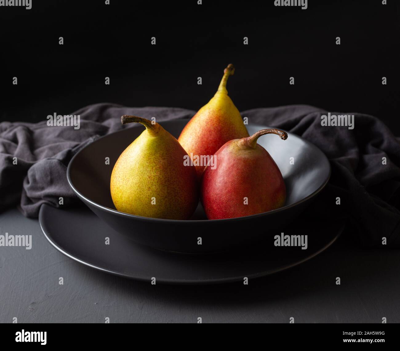 Drei frische saisonale Birnen auf einem dunklen Hintergrund, dunkel Essen Stockfoto
