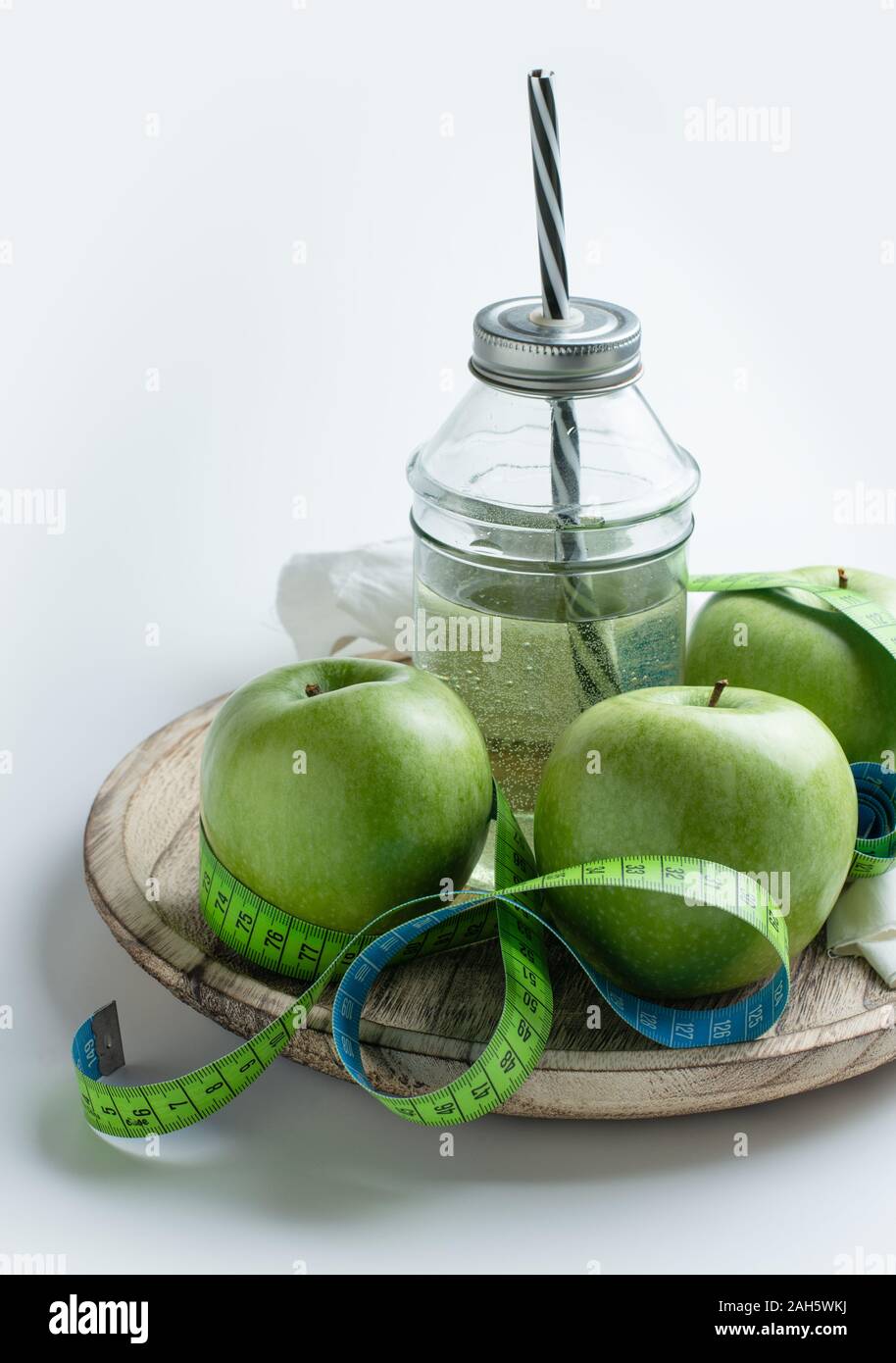 Grüne Äpfel und Apfelsaft mit maßband Gewicht in der Diät zu steuern Stockfoto