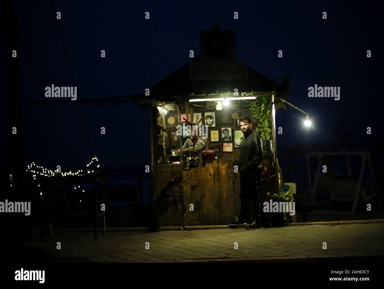 Gaza, Gaza, Palästina. 25 Dez, 2019. Eine palästinensische verkauft heisse Getränke am Strand von Gaza, den 25. Dezember 2019, und die Wellen sind hoch während der starke Wind schlagen der Strand in Gaza Stadt. Credit: Mahmoud Issa/Quds Net News/ZUMA Draht/Alamy leben Nachrichten Stockfoto