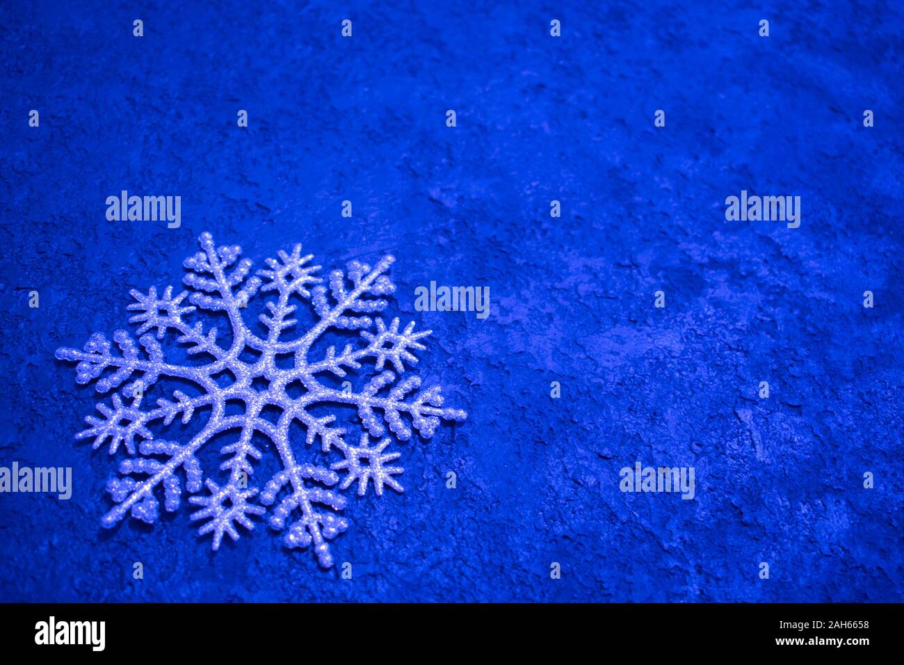 Weihnachten Hintergrund. Große silberne Schneeflocke auf blauem Hintergrund. Kopieren Sie Platz. Minimalistisches Design. Stockfoto