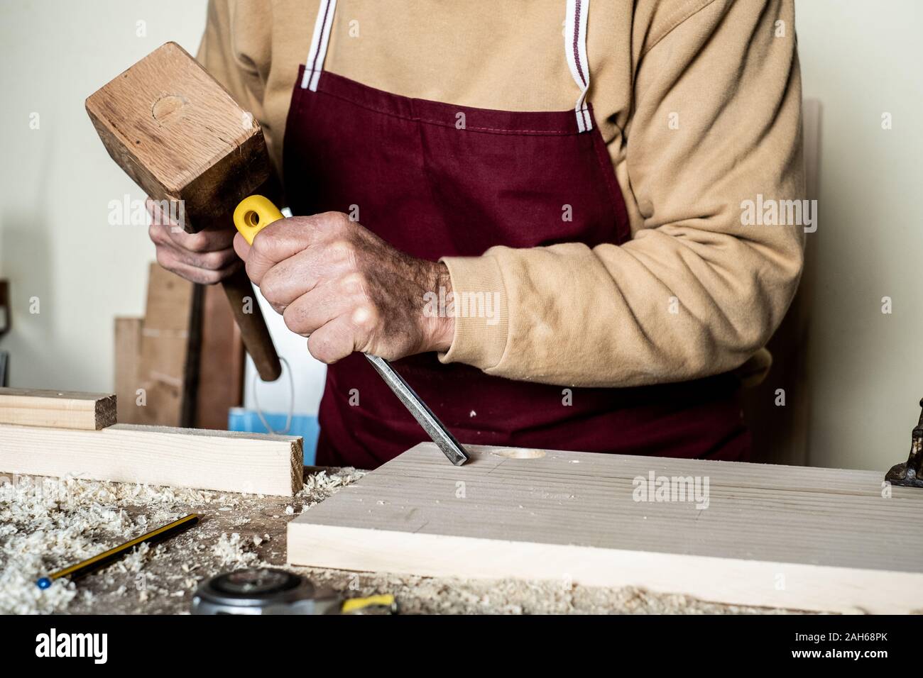 Carpenter's Hände mit Meißel auf der Holzbearbeitung Sitzbank Stockfoto