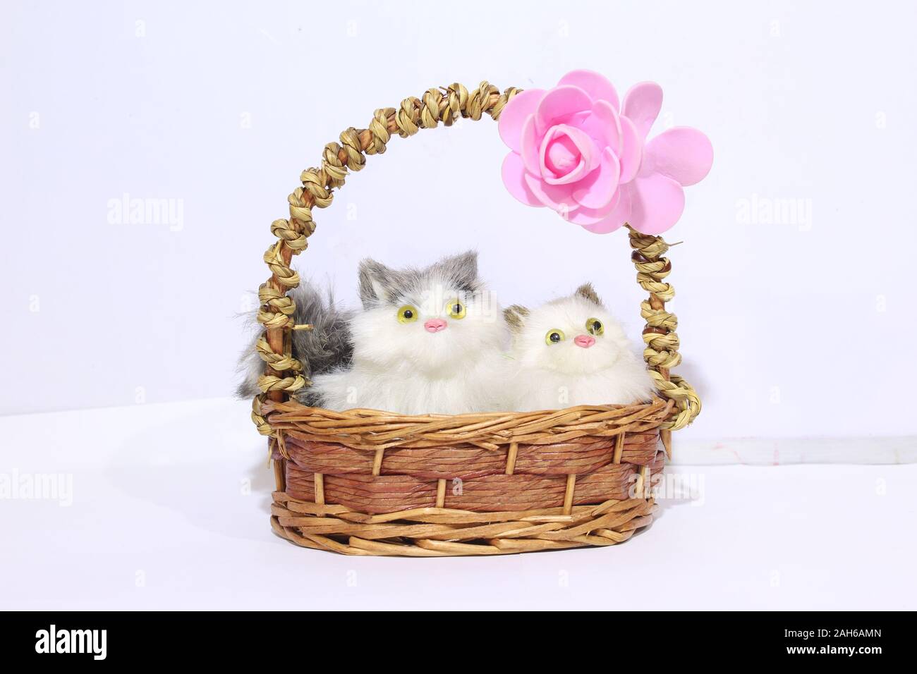 Zwei Katzen in einem Korb mit rosa Rosenblüte Stockfoto
