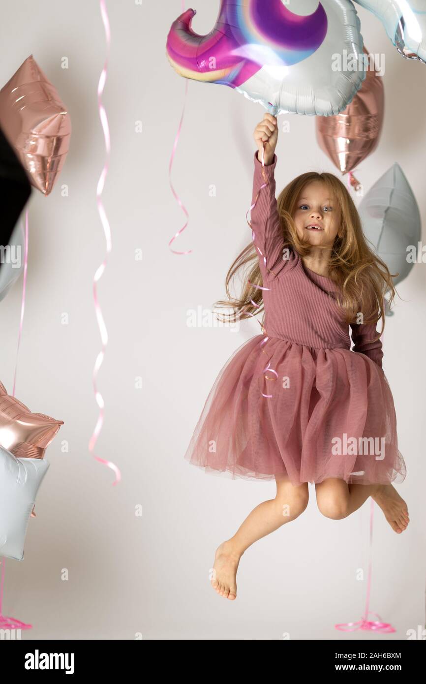 Mädchen springt und hält einen Ballon in der Hand. Stockfoto