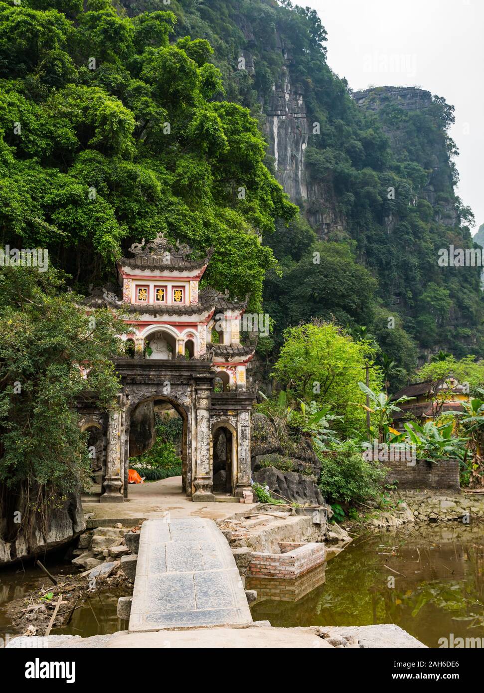 Eingang zum vietnamesischen buddhistischen Tempel über bogenförmige Brücke, Bich Dong Pagode, Tam Coc, Ninh Binh, Vietnam, Asien Stockfoto