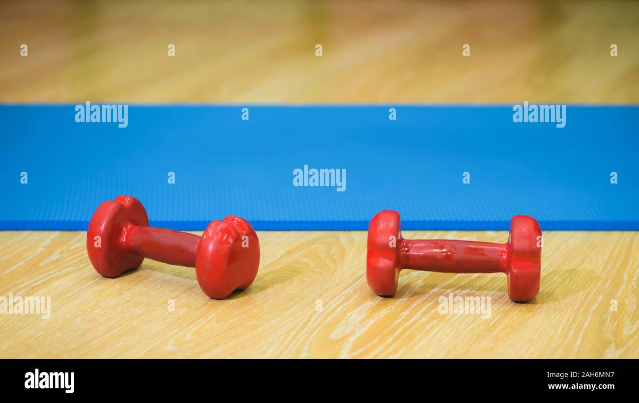Zwei Hanteln liegen auf einem blauen Matte Stockfoto
