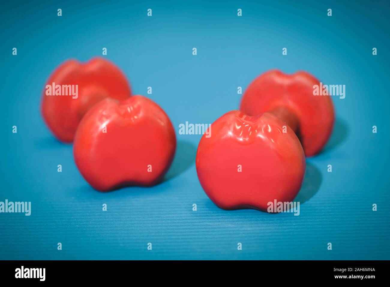 Zwei Hanteln liegen auf einem blauen Matte Stockfoto