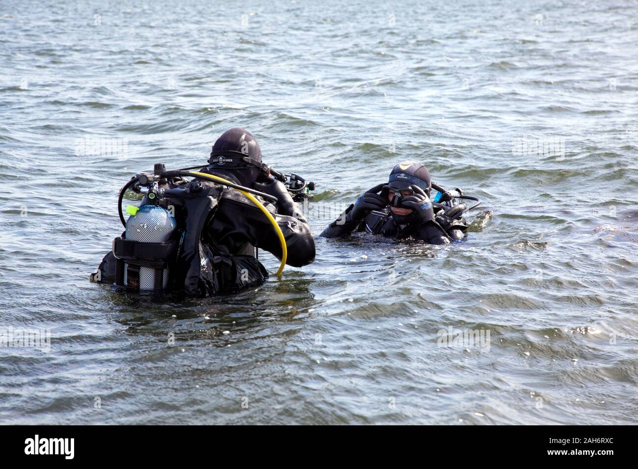 Zwei Taucher in voller Tauchausrüstung bereit, um unter Wasser zu gehen Stockfoto