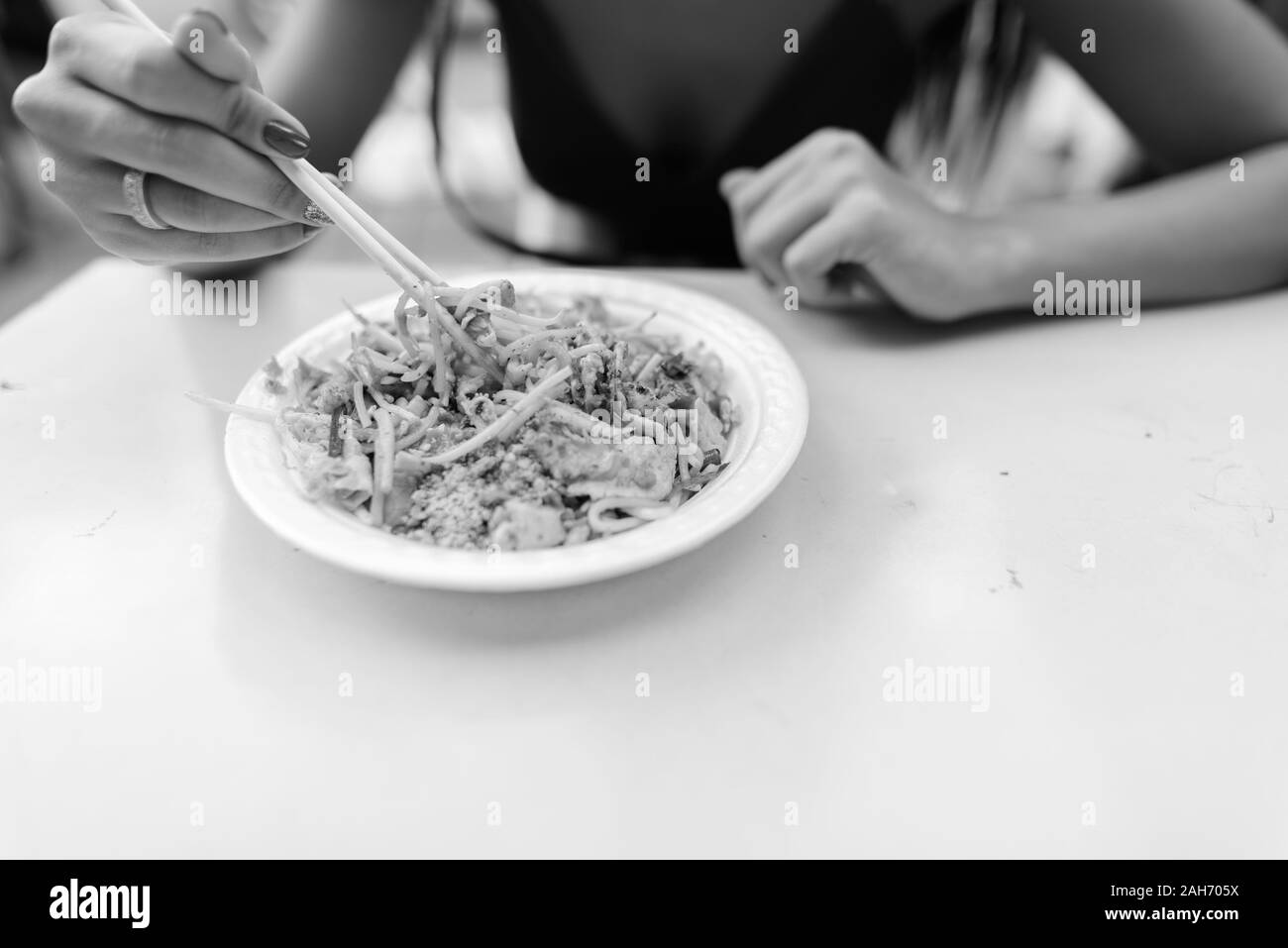 Hand des jungen Touristen Frau essen Pad Thai Thai traditionelle Speisen Stockfoto