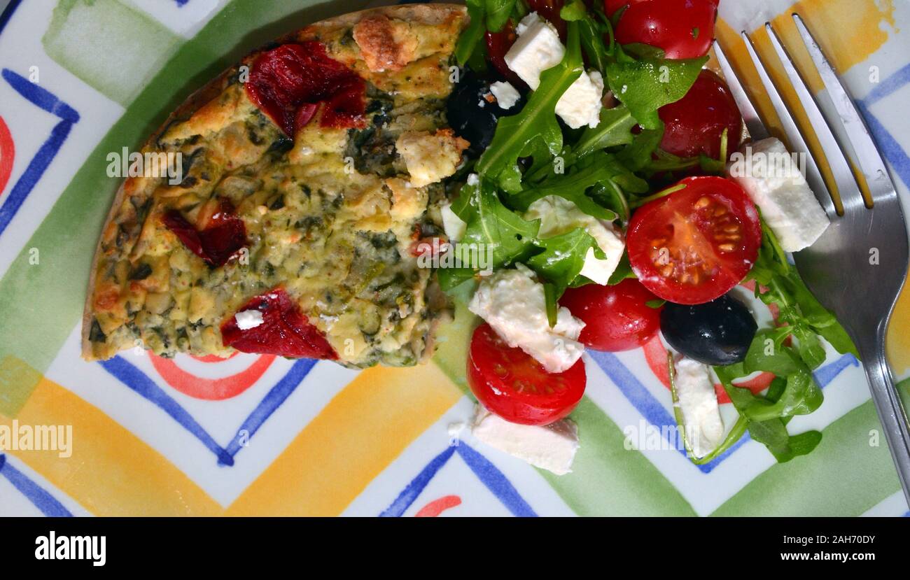 Eine Ansicht von oben auf einen Teller mit Gemüse Quiche und Salat auf einen Teller mit der Gabel Stockfoto